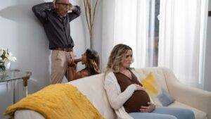 Pregnant woman on sofa with brunette and tense man
